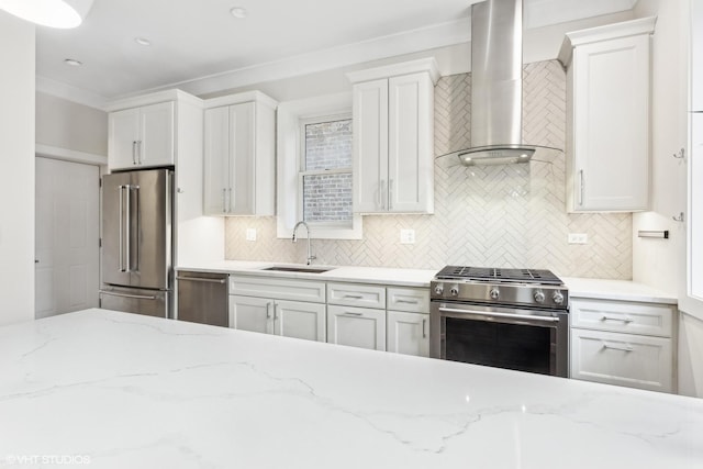 kitchen with wall chimney exhaust hood, stainless steel appliances, tasteful backsplash, white cabinetry, and sink