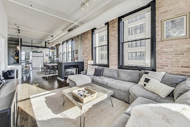 living room featuring hardwood / wood-style floors, brick wall, and a fireplace