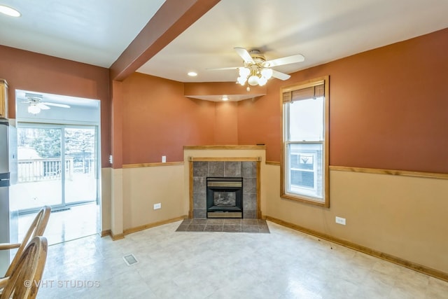 unfurnished living room featuring ceiling fan, beam ceiling, and a fireplace