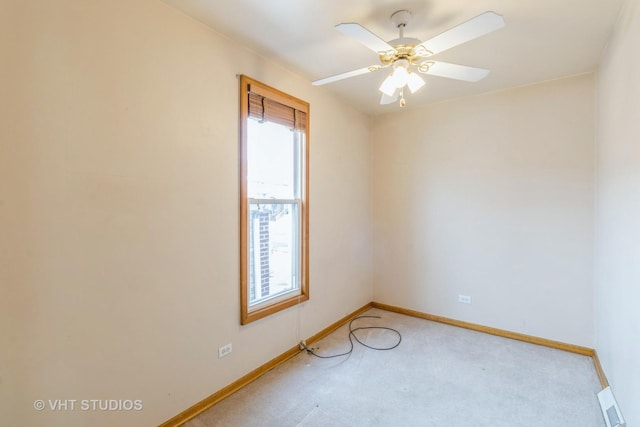 empty room featuring light carpet, ceiling fan, visible vents, and baseboards