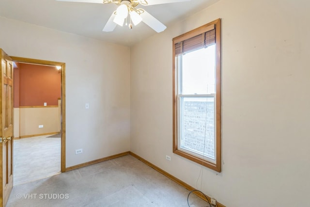 empty room featuring a ceiling fan, light carpet, and baseboards