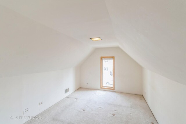 bedroom with light carpet and lofted ceiling