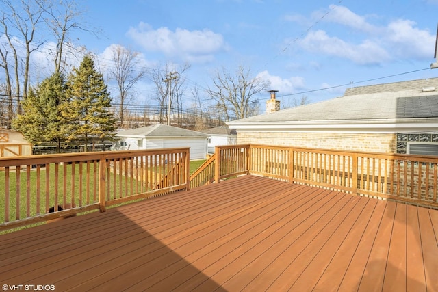 deck featuring a lawn and an outdoor structure