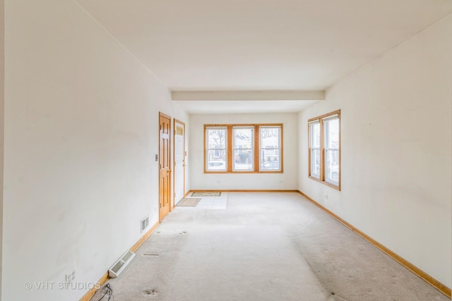 unfurnished room featuring visible vents, light carpet, and baseboards