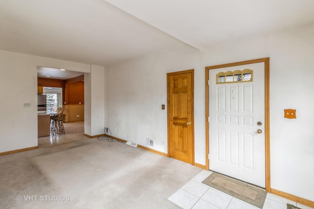 entryway with carpet floors, baseboards, and visible vents