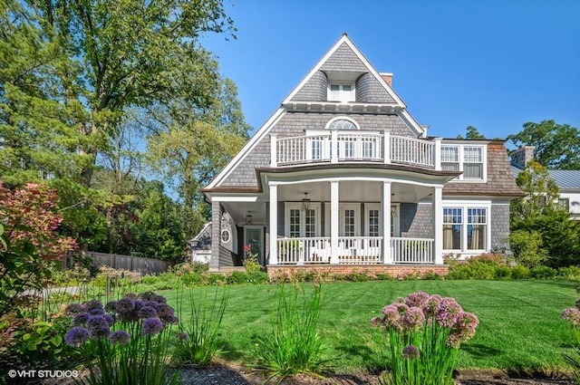 view of front of property with a porch, a balcony, and a front yard