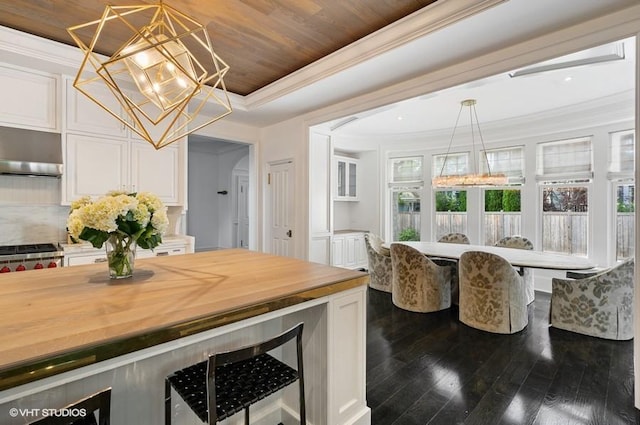 kitchen featuring butcher block countertops, white cabinets, ornamental molding, wood ceiling, and an inviting chandelier