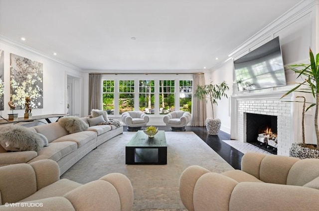 living room featuring crown molding, a brick fireplace, and light wood-type flooring