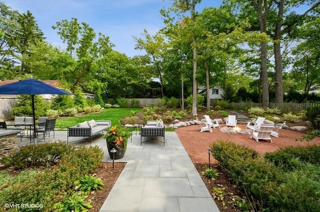 view of home's community featuring an outdoor living space with a fire pit and a patio area