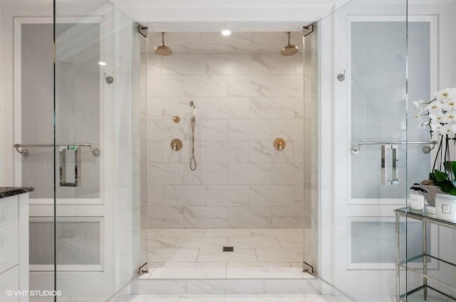 bathroom with tiled shower and vanity