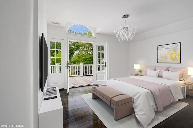 bedroom featuring dark wood-type flooring, access to exterior, and an inviting chandelier