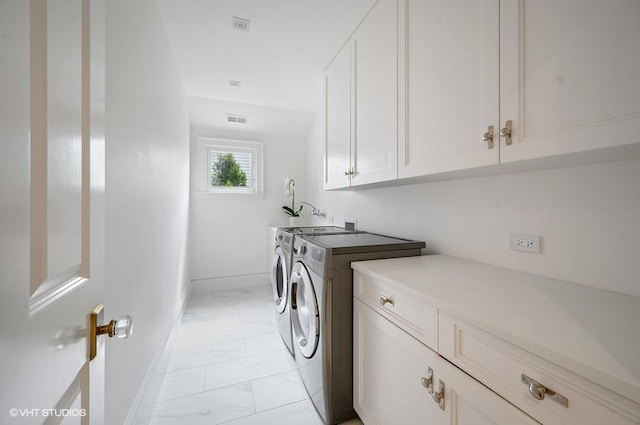 laundry area featuring cabinets and washer and clothes dryer