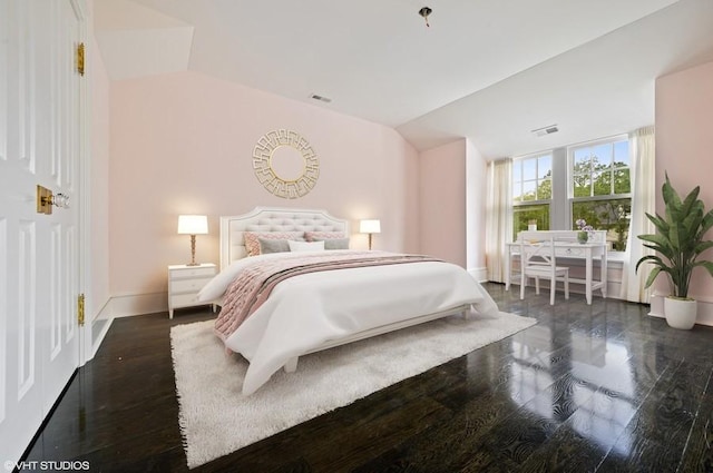 bedroom with lofted ceiling and dark hardwood / wood-style floors