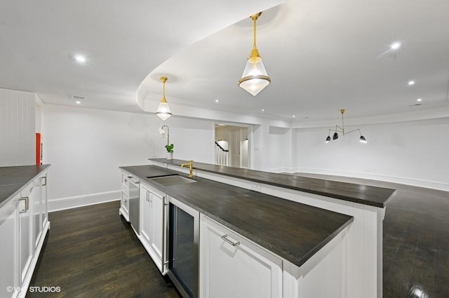 kitchen featuring white cabinetry, beverage cooler, and decorative light fixtures