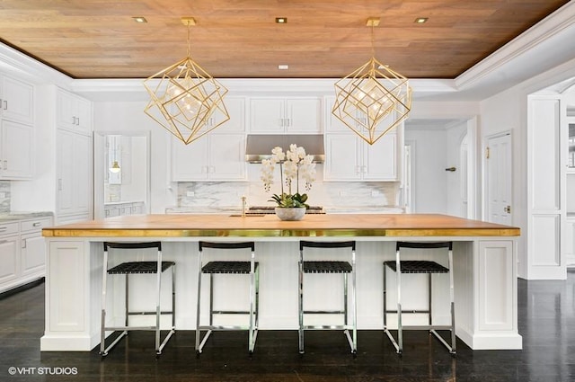 kitchen featuring wooden ceiling, a center island with sink, white cabinets, and wood counters