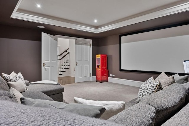 home theater room featuring a tray ceiling and carpet flooring