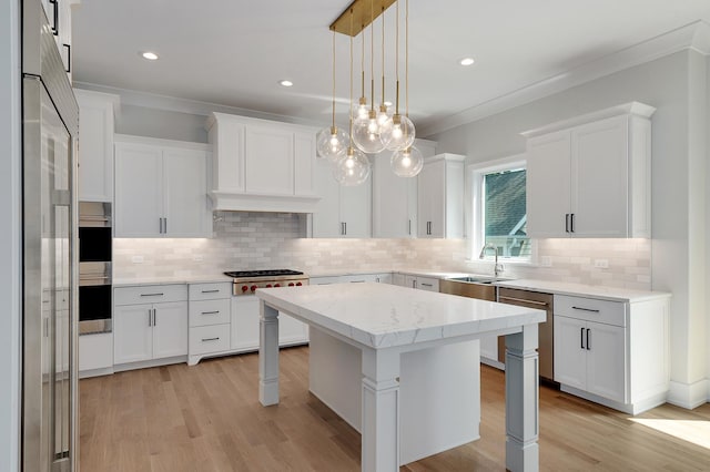 kitchen featuring white cabinetry, hanging light fixtures, appliances with stainless steel finishes, and a center island