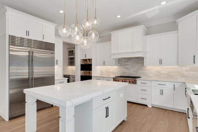 kitchen with white cabinetry, appliances with stainless steel finishes, tasteful backsplash, and a center island