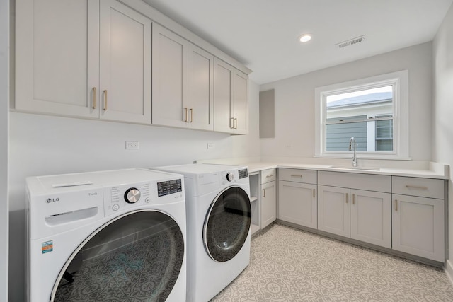 clothes washing area with cabinets, sink, and washing machine and dryer