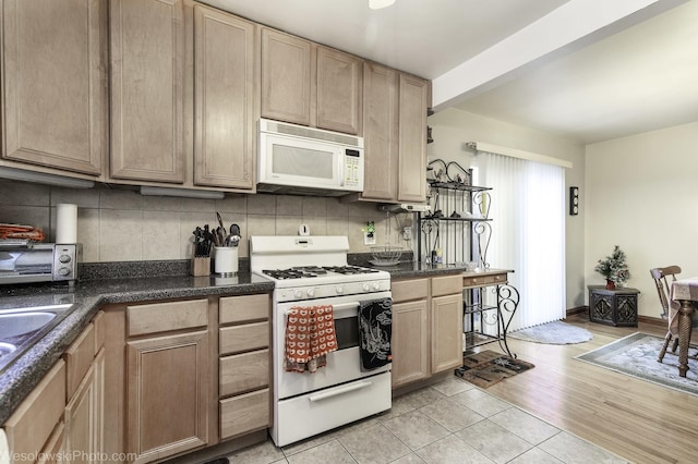 kitchen with light tile patterned flooring, white appliances, light brown cabinets, and tasteful backsplash