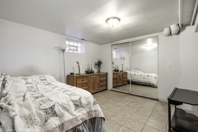 bedroom with light tile patterned floors and a closet