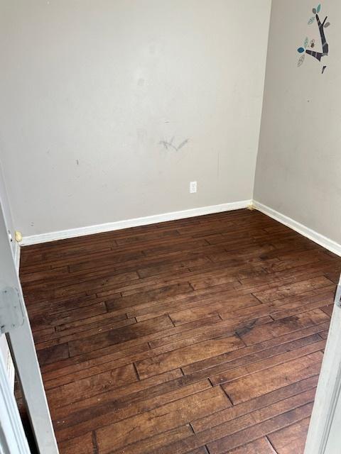 spare room featuring dark wood-type flooring