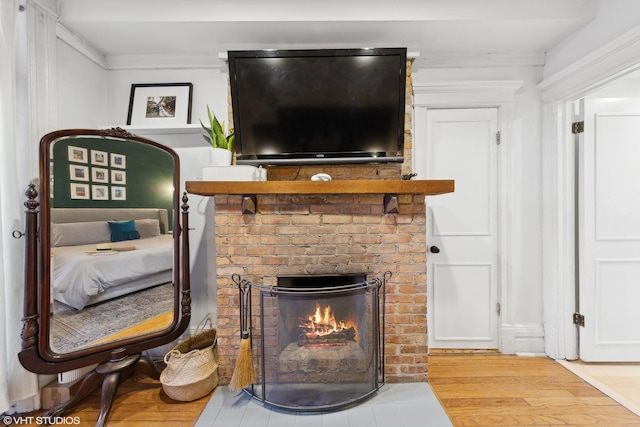 living room with a fireplace, light hardwood / wood-style floors, and ornamental molding