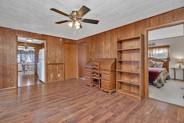 office space with ceiling fan, hardwood / wood-style floors, and wooden walls