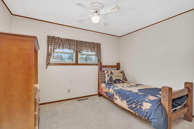 bedroom with ornamental molding, light colored carpet, and ceiling fan