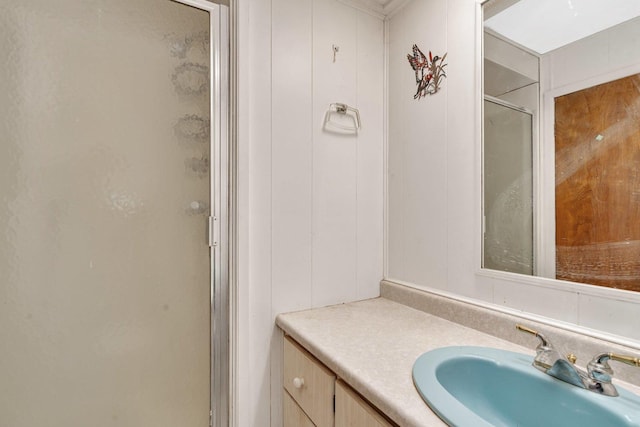 bathroom with vanity, wood walls, and walk in shower