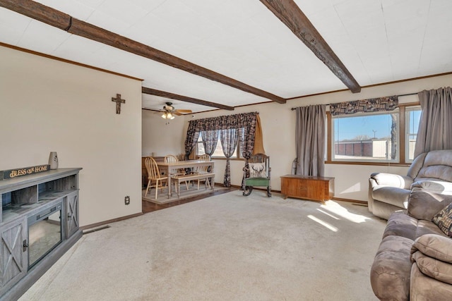 living room with beamed ceiling, carpet, and a wealth of natural light