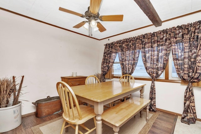 dining area with ceiling fan, wood-type flooring, ornamental molding, and beamed ceiling