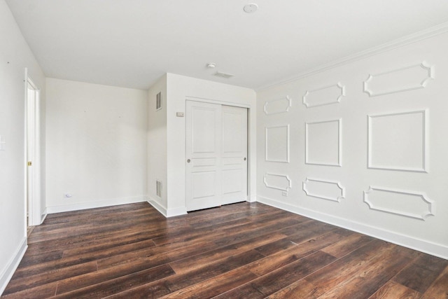 unfurnished bedroom with dark wood-type flooring and a closet