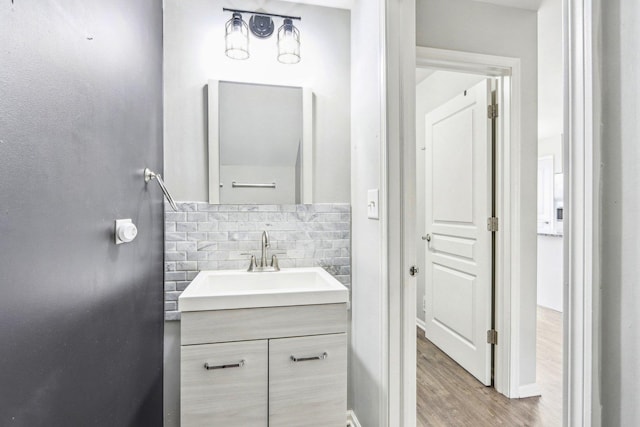 bathroom featuring vanity, wood-type flooring, and backsplash