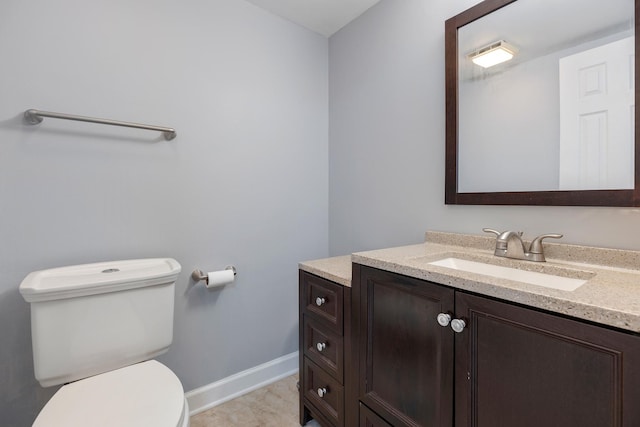 bathroom with vanity, toilet, and baseboards