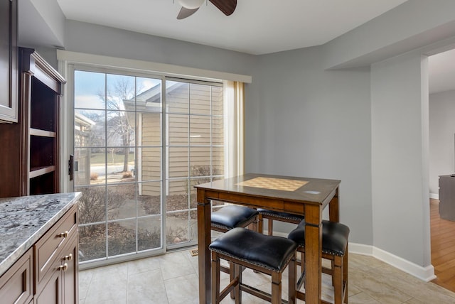 dining area featuring ceiling fan and baseboards