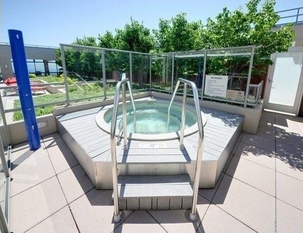 view of swimming pool with a hot tub