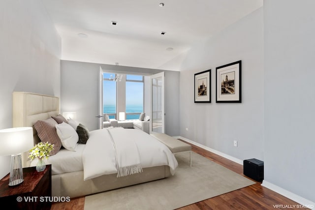 bedroom featuring a water view and hardwood / wood-style flooring