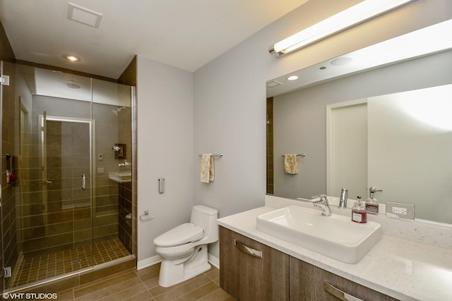 bathroom with vanity, tile patterned flooring, a shower with door, and toilet