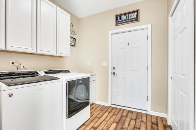 washroom featuring washing machine and dryer, hardwood / wood-style floors, and cabinets