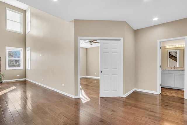 unfurnished room with sink, wood-type flooring, and ceiling fan