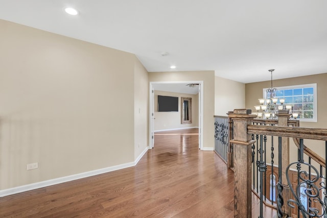 corridor featuring a notable chandelier and hardwood / wood-style floors