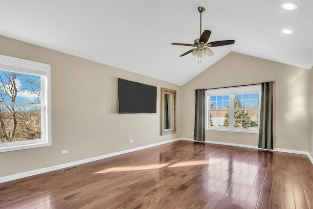 spare room with lofted ceiling, hardwood / wood-style flooring, ceiling fan, and plenty of natural light