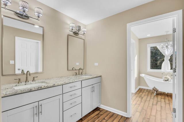 bathroom featuring a tub to relax in, hardwood / wood-style floors, and vanity