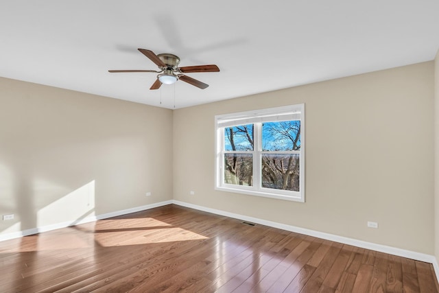 empty room with hardwood / wood-style floors and ceiling fan