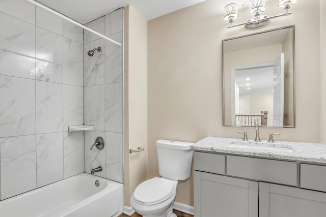 full bathroom featuring tiled shower / bath, vanity, and toilet