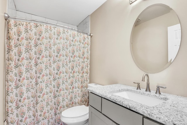 bathroom featuring curtained shower, vanity, and toilet