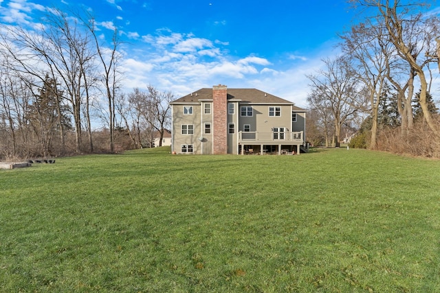 rear view of house featuring a yard