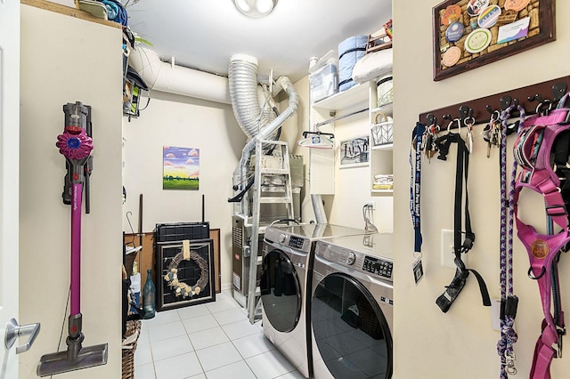 clothes washing area featuring light tile patterned flooring and washing machine and dryer