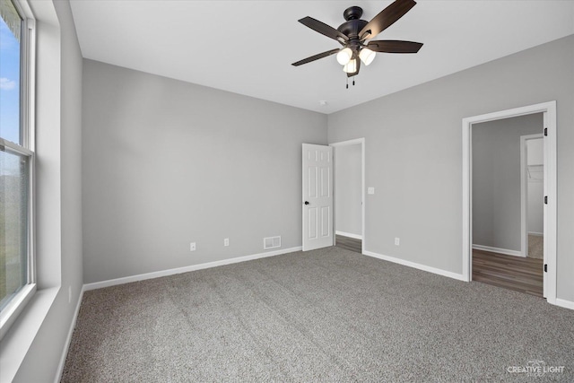 unfurnished bedroom with dark carpet and ceiling fan